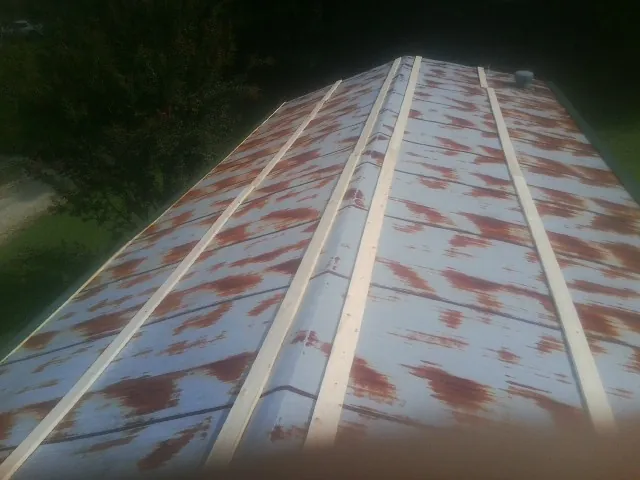 Rusted metal roof panels with new wood purlins before replacement — Storm Damage Roof Repair in Dows by Roofing Brothers