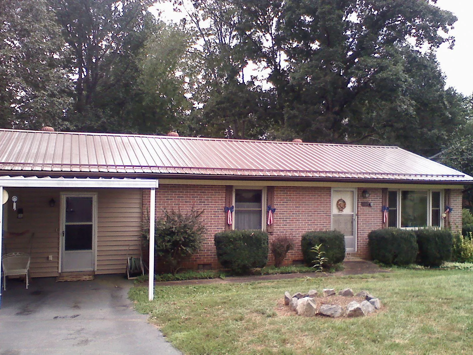 Bronze metal roof and carport on a brick ranch home — Roof Repair work by our crew in Dows